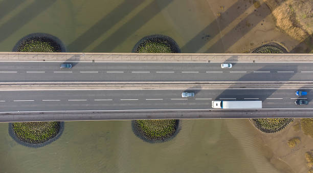 widok z drona patrzącego w dół na ruch na moście drogowym przecinającym dużą rzekę w suffolk, wielka brytania - river orwell zdjęcia i obrazy z banku zdjęć