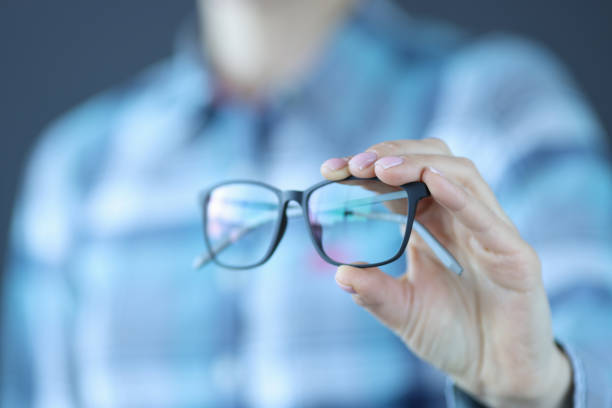 istock Glasses with black optics are held in hand 1303855085