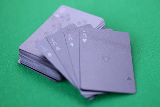 istock Black playing cards with aces lie on green gaming table 1303855094