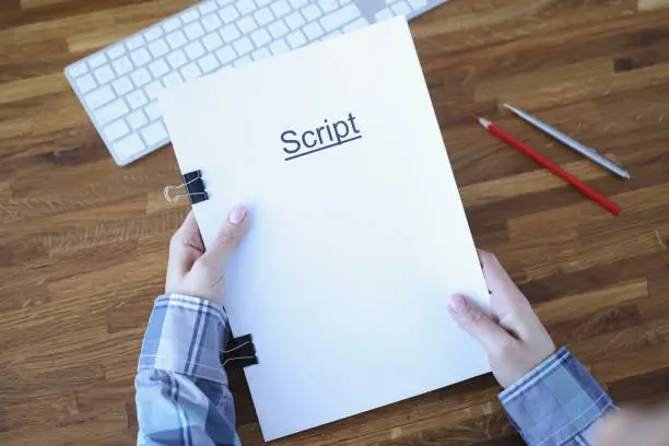 Screenwriter holds folder of documents labeled script. Development of plots for films and series concept