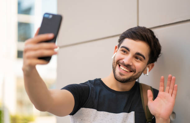 istock Young man having a video call on mobile phone. 1303855611