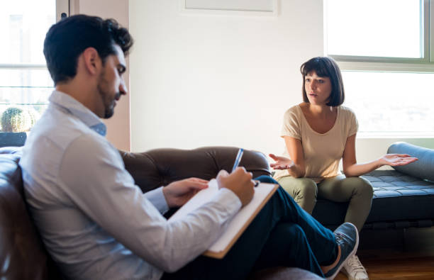 istock Psychologist talking with patient on therapy session. 1303855652