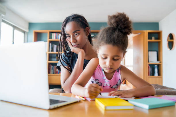 istock A mother helping her daughter with homeschool. 1303855724