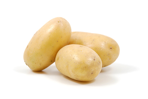 Three raw potatoes on a white background