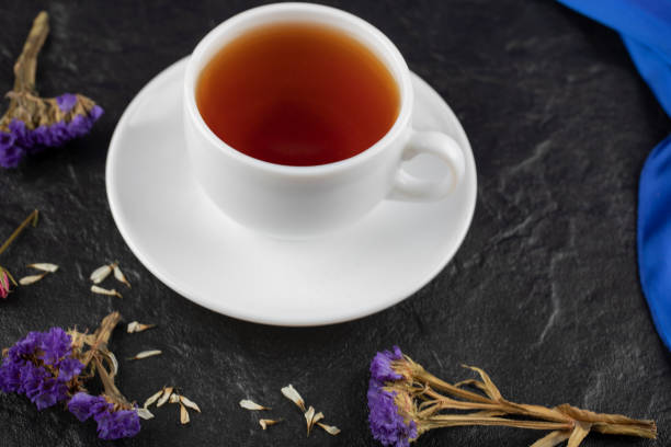 istock A cup of tea with dried flowers on a black background 1303857666