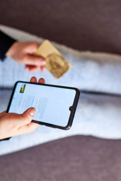 istock A woman makes purchases on the Internet using a smartphone and her bank card. 1303857714