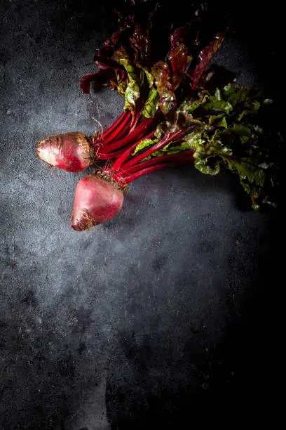 Fresh organic beet, beetroot on dark background. Copy space. Top view. Beetroot with herbage on dark background.