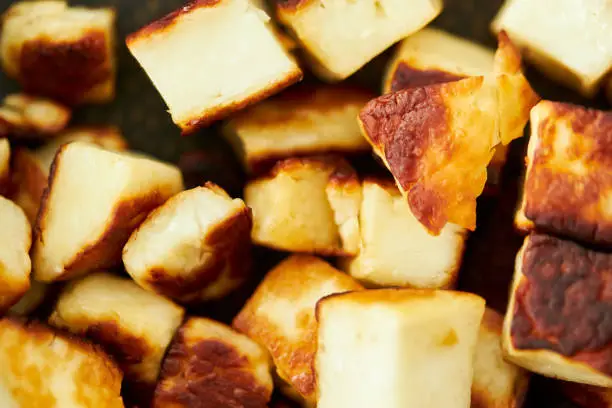A close-up of freshly grilled and diced halloumi cheese, photographed in high resolution and in full format