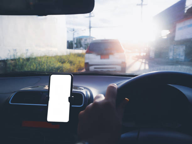 istock Blank empty screen smartphone on holder in car use for Navigation or GPS. Car interior view. 1303860280