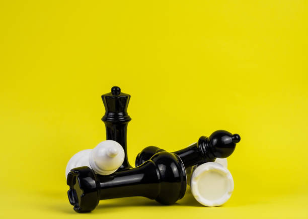 istock Large chess pieces on a yellow background. 1303860364