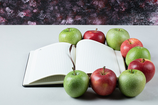 Red and green apples with a blank recipe book aside. High quality photo