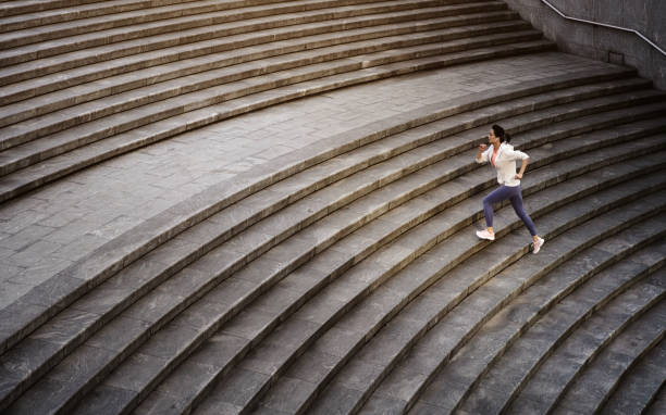 istock Young sportswoman jogging up the steps. 1303865559