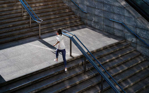 Beautiful fit woman in good shape jogging alone in city