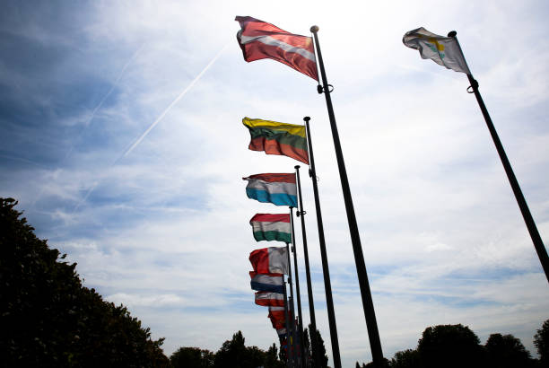 istock Low angle view of country flags on flagpoles 1303866868