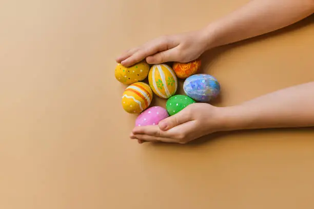 Colorful easter wooden eggs in child hands after egg-hunt