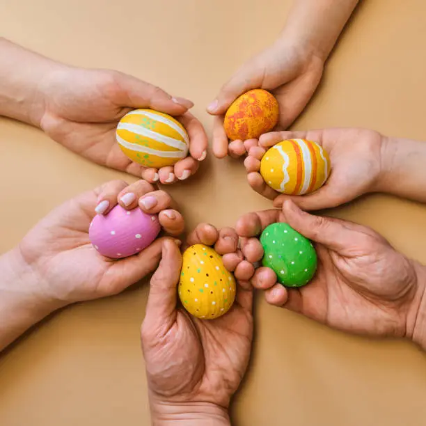 Colorful easter wooden eggs in hands of a friendly family after egg-hunt