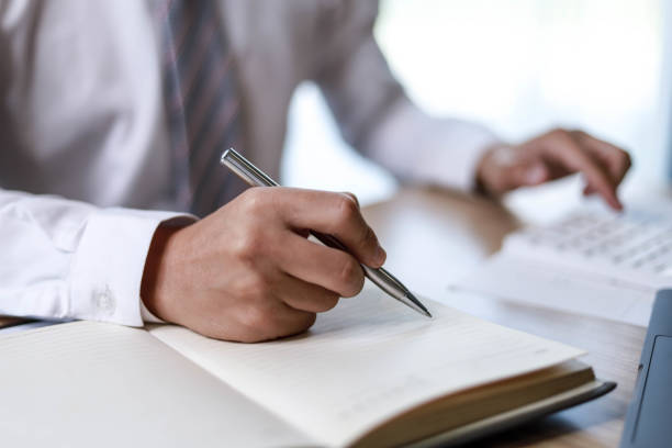istock Business man is taking a note of work to reminders in his appointment book, he takes notes after every business meeting, a reminder idea. 1303869993