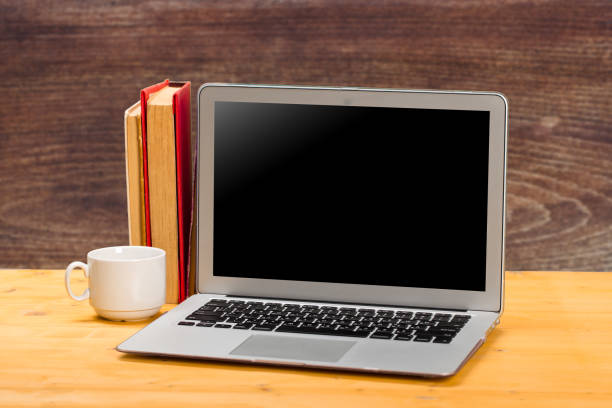 istock mocap Laptop with blank screen, coffee and books or notebooks on a wooden table. 1303870419