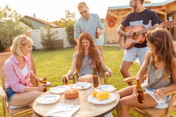 istock Friends playing the guitar at backyard barbecue party 1303876081