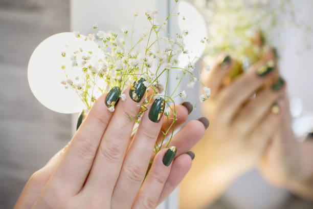 istock Hands with beautiful khaki manicure and gold foil. 1303878520