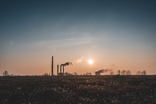 A view of the dark silhouette of the power plant against the backdrop of the setting sunBlachownia Power Plant - block thermal condensing power plant, with a closed cooling water system, Kedzierzyn-Kozle, south-west Poland.