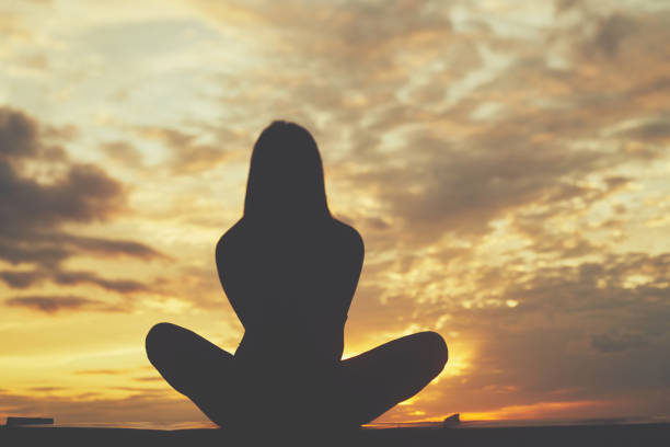 istock Woman practicing yoga during beautiful sunset with clouds 1303883214