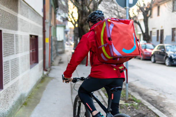 istock Young man working in delivery service. delivery man with bicycle 1303885899