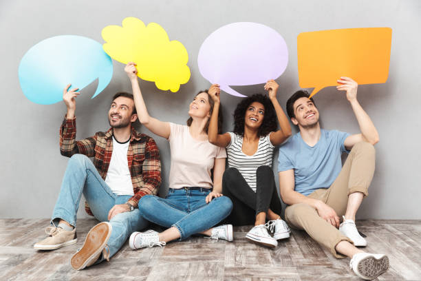 istock Happy group of friends holding speech and thoughtful bubbles. 1303887140