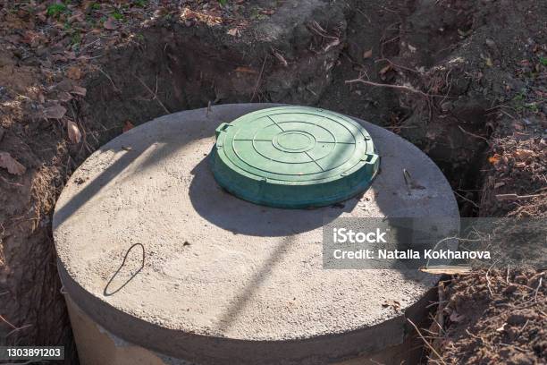 Septic Tank Made Of Concrete Rings With A Hatch For A Private Country House Wastewater And Sewerage Drainage Stock Photo - Download Image Now