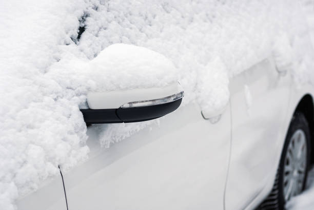 istock White car in snow, side view mirror closeup 1303892281