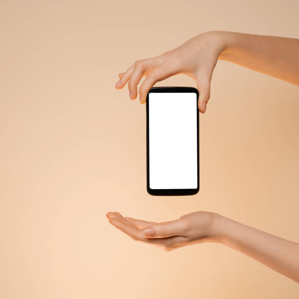 istock Smartphone with a blank screen in a woman's hand on a orange background. 1303892799
