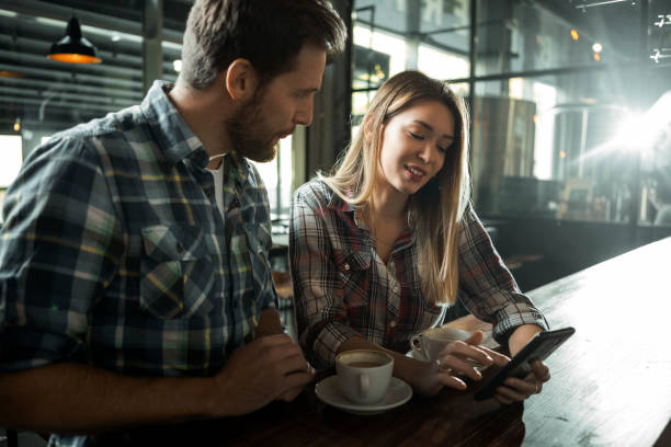 istock Friends at the cafe using a mobile phone talking 1303895167