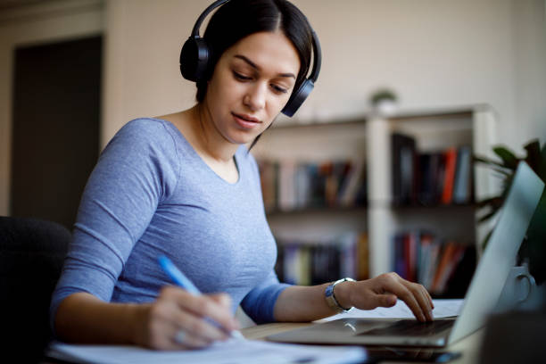 istock Young woman with wireless headphones working from home 1303895175