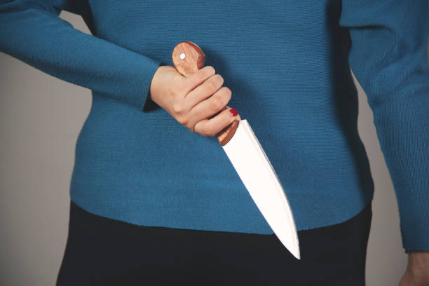 istock woman hand holding knife in back 1303895339