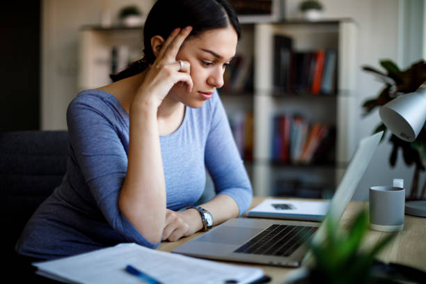 gestresste und müde geschäftsfrau arbeitet von zu hause aus auf laptop zu hause - unemployment fear depression women stock-fotos und bilder