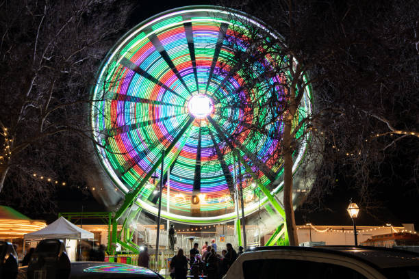 grande roue dans le vieux sacramento - blurred motion amusement park spinning lighting equipment photos et images de collection