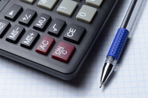 istock a ballpoint pen and a micro calculator lie on a squared notebook. close-up. 1303898579