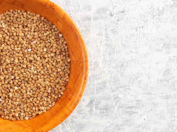 istock Buckwheat in a wooden bamboo cup on a white concrete background with copy space 1303901495