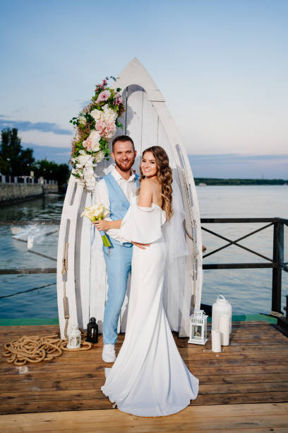 istock beautiful wedding ceremony by water on dock. bride and groom. 1303901776