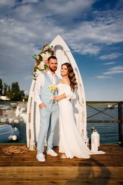 istock wedding ceremony by water on dock. bride and groom. 1303901933