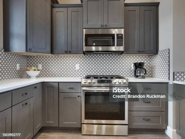 Modern Light And Bright Kitchen Dark Grey Wood Floors With White Countertops And Dark Grey Cabinets Straight On View Stock Photo - Download Image Now