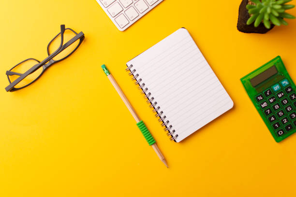 istock Top view of the workspace on yellow background 1303902913