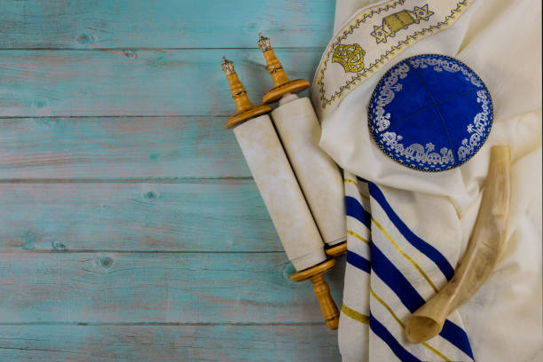 Jewish Orthodox religious symbols prayer book with torah scroll and shofar horn, prayer shawl tallit Jewish Orthodox religious symbols prayer book with torah scroll and shofar horn, prayer shawl tallit in a synagogue traditional ceremony photos stock pictures, royalty-free photos & images