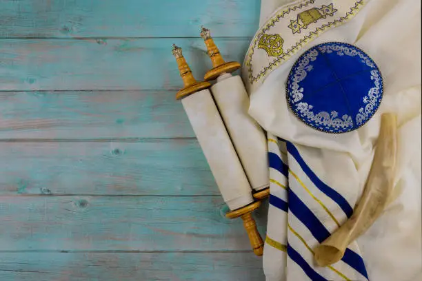Jewish Orthodox religious symbols prayer book with torah scroll and shofar horn, prayer shawl tallit in a synagogue