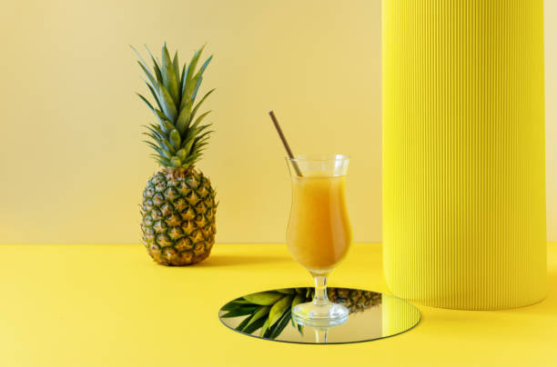 istock Pineapple fresh juice in glass on yellow background. 1303904538