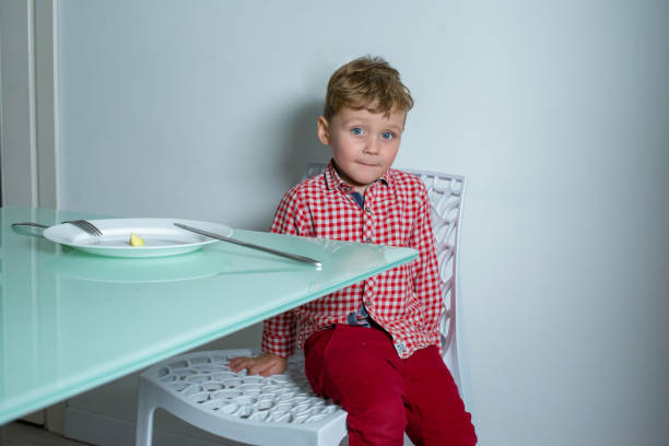 istock Boy sitting on a chair and looking at the camera. 1303905377