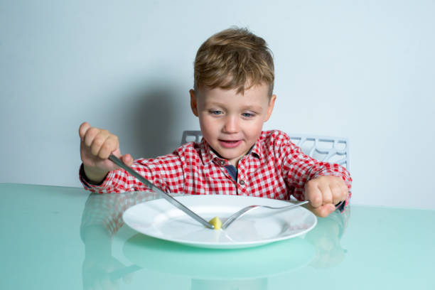 istock Child sits at the table and eats food. 1303905403