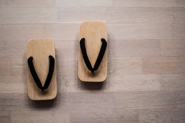 Traditional Japanese wooden geta clogs on timber background