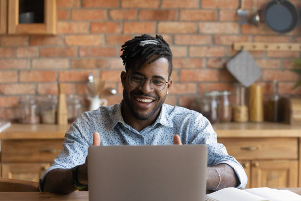 istock Close up smiling African American man using laptop, video call 1303905743