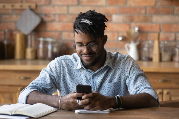 istock Close up satisfied African American man using phone, browsing apps 1303905771